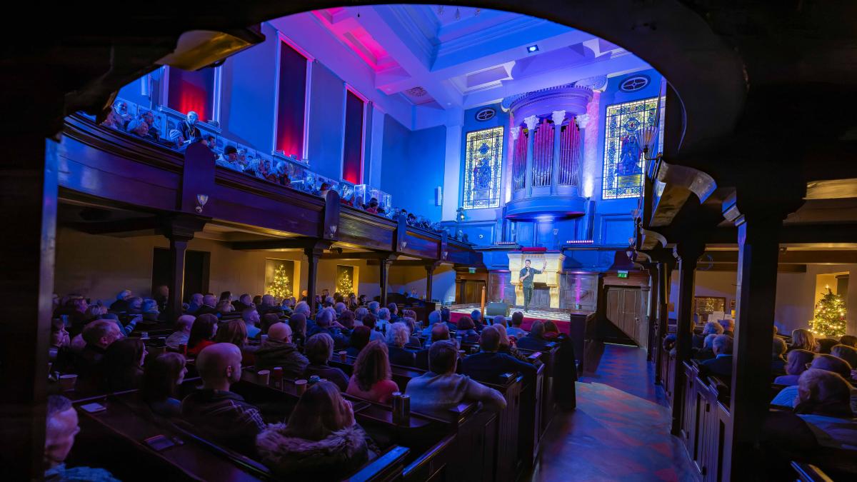 audience watching a performer on stage at portico