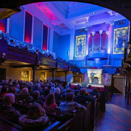 audience watching a performer on stage at portico