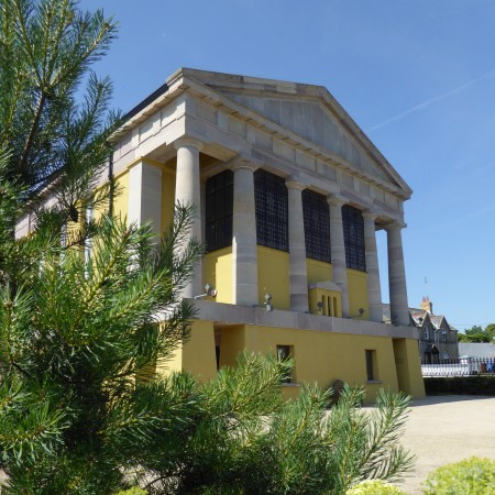 An exterior photo of Portico from a low angle with a backdrop of perfect clear blue skies.